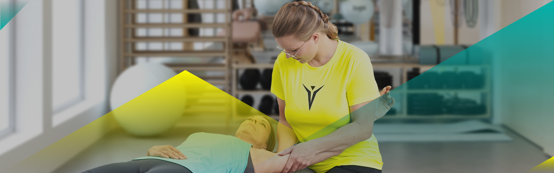 Eine Patientin der Physiotherapie wird auf dem Rücken liegend an der Schulter behandelt