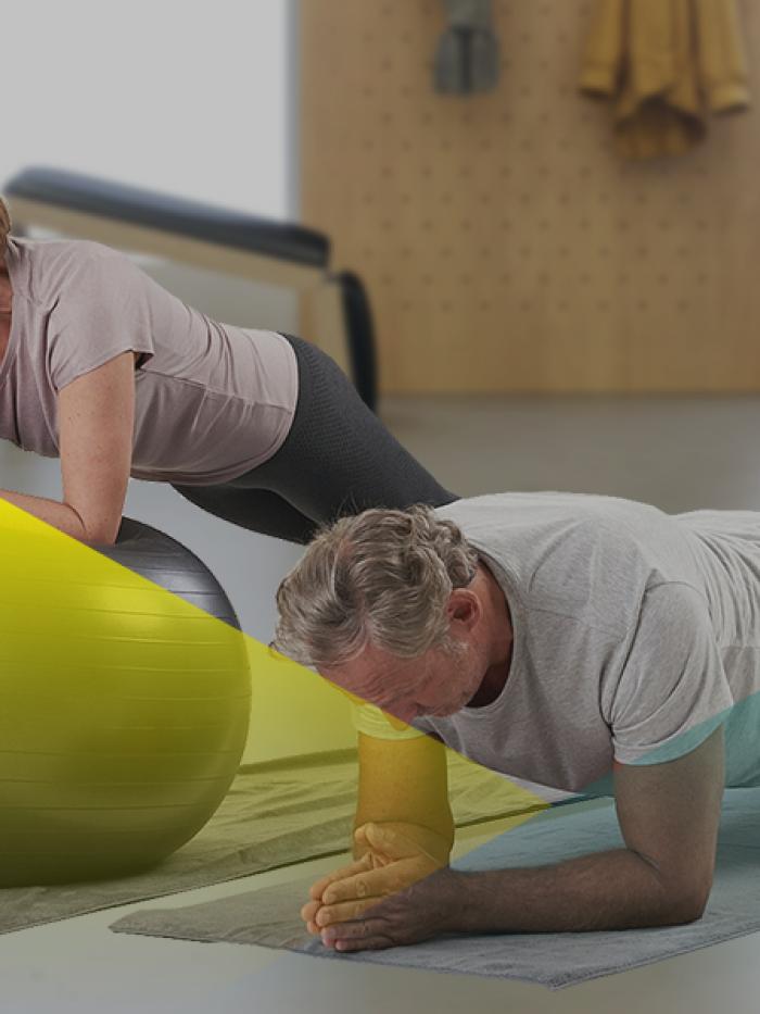 Eine Trainerin macht mit zwei Kunden Kraftaufbautraining im Gesundheitsstudio